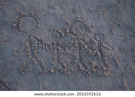The drawing of the family on the sand on the beach at sunset
