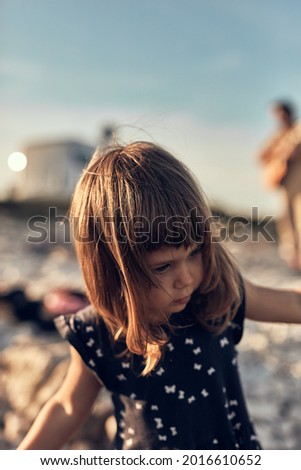 Little girl playing on a sea shore.