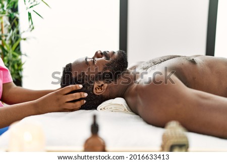 African american man reciving head massage at the clinic. Royalty-Free Stock Photo #2016633413