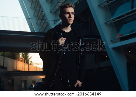 Pure commercial photography for advertising. Stylish man stands in an urban setting in the evening