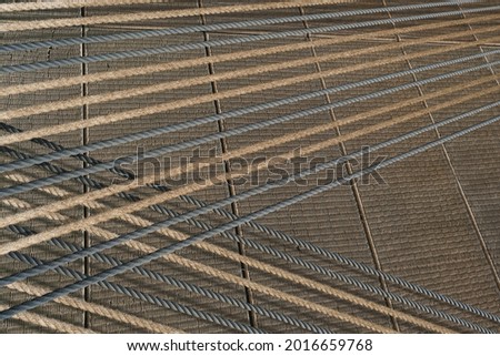 Decorative natural wall. Crossing oblique tightly stretched jute durability ropes over textured biodegradable braided wicker mats. Eco background. Environmental conservation,eco-friendly house concept Royalty-Free Stock Photo #2016659768