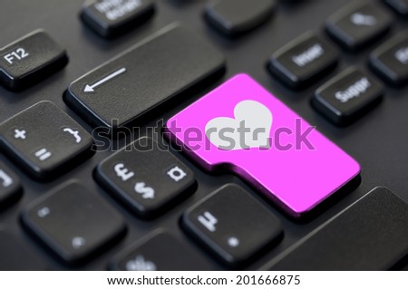 Close up of a pink heart return key on a black computer keyboard