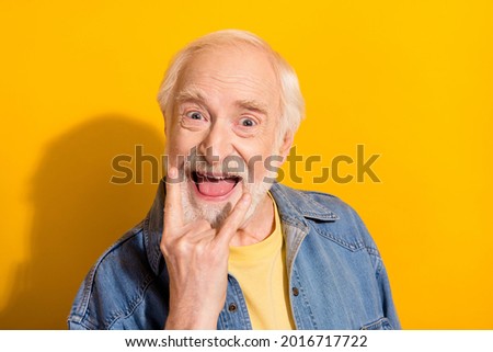 Photo of excited cheerful aged person fingers show heavy metal symbol isolated on yellow color background