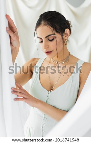 brunette woman in dress posing on white