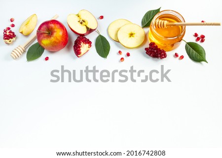 Concept of traditional Jewish holiday of Rosh Hashanah. New Year. Pomegranates, honey and apples on a white background. Place for your text.