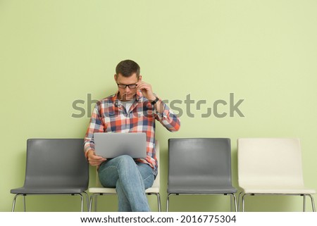 Man with laptop waiting for job interview indoors