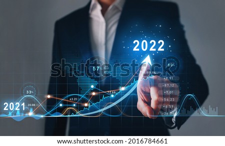 Businessman draws  increase arrow graph corporate future growth year 2021 to 2022.   Development to success and motivation. Royalty-Free Stock Photo #2016784661