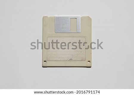 3.5-inch floppy disk for data storage in the past. Cream floppy disk on white background.