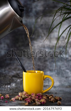 Hot coffee in a cement grey background with warm, light atmosphere, on a dark background, with steam rosebuds around coffee space 