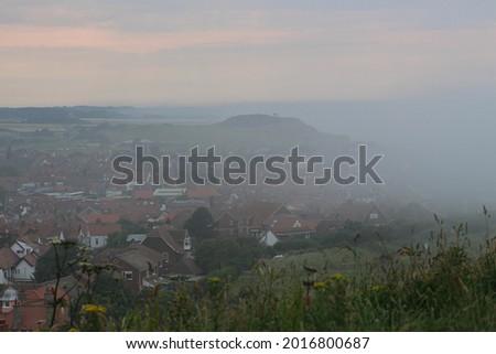 Photo of fog creeping onto land coastline landscape