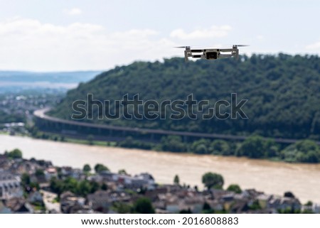 The drone hovers over the grape hills and countryside, the plastic propellers are on and the camera on the gimbal is visible.