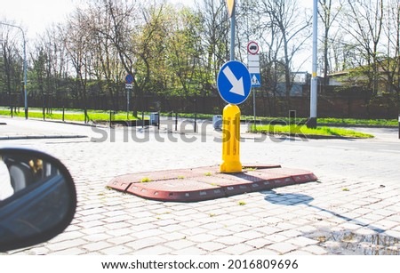 Traffic circle sign in the middle of the road. 