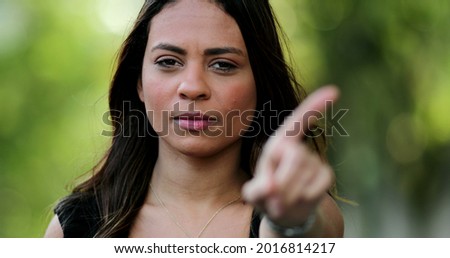 Woman annoyed making stop sign with hand, saying no, expressing defense or restriction.