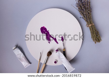 Purple strokes on a round canvas, brushes, mastikhin, paints and a bunch of lavender. Beautiful layout of the artist. High quality photo