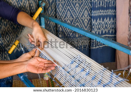Crafts and craftsmanship. Traditional Isan Thai silk indigo weaving.Craftsmen of Thai Silk. selective focus Royalty-Free Stock Photo #2016830123