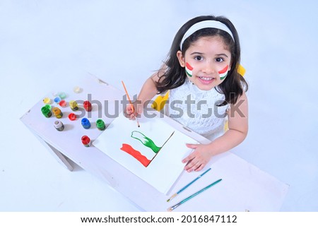 Little girl making Indian flag using poster colors on the occasion of Independence day India celebrations Royalty-Free Stock Photo #2016847112