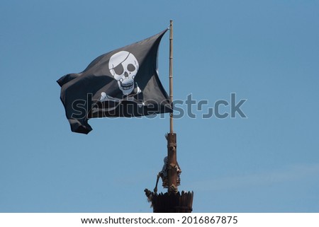 A pirate flag is displayed against a blue sky.