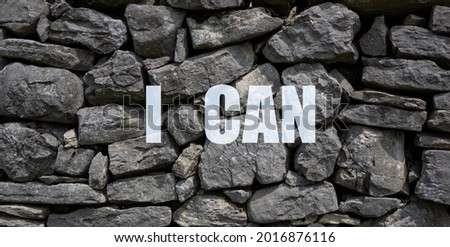 Wall of large gray stones with a semitransparent white writing I CAN. Used the wall of an ancient house in the province of Treviso, Italy.