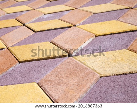 Side view of multicolored outdoor floor tiles laid in geometric patterns.