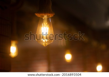Vintage Light bulb, Lamp hanging with Blurred background at Coffee shop in india for decorate and background picture. selective focus.