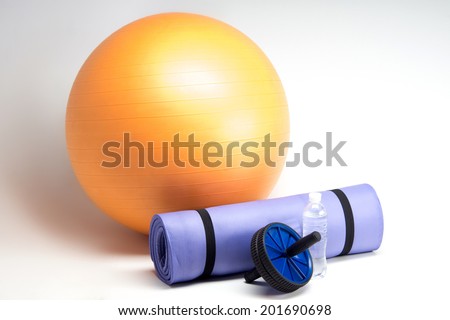 Sports equipment, Fit ball, yoga mat, abs roller and water bottle closeup isolated on white