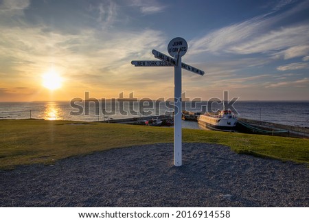 The sun setting behind the iconic signpost at John O'Groats in the Scottish Highlands, UK Royalty-Free Stock Photo #2016914558