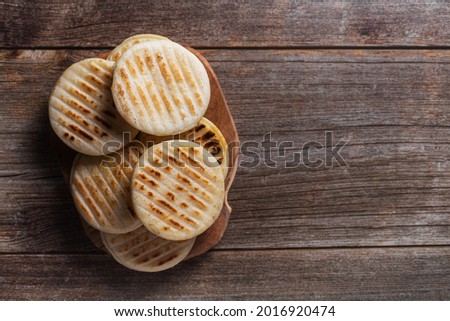 Arepa is a type of meal made from ground corn dough, cornmeal, top view with copy space Royalty-Free Stock Photo #2016920474