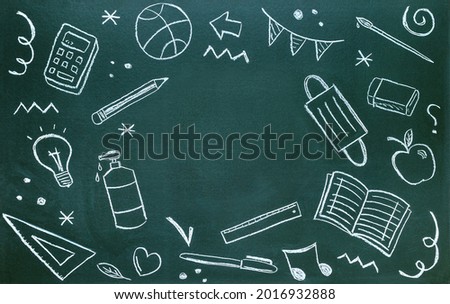 Blackboard written with chalk with school supplies, coronavirus protections and copy space. Back to school concept