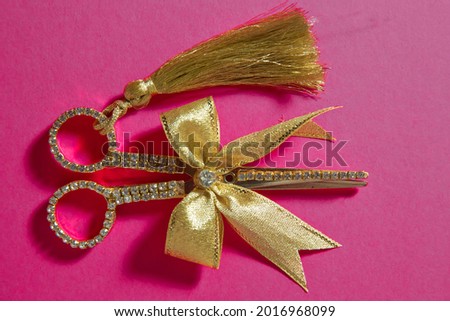 Pink ribbon on gold scissors Pink background . gold scissors pink flat lay minimal background