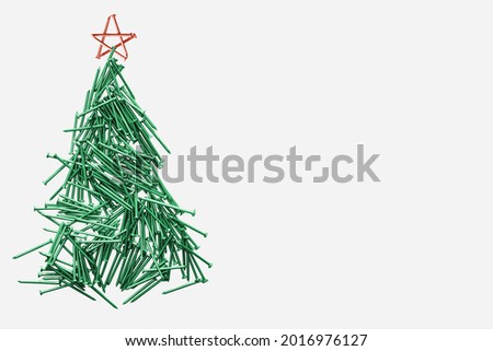  christmas tree folded of green nails with red star isolated on white background.