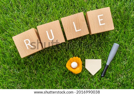 Baseball rule; Wooden blocks with "RULE" text of concept and baseball equipment toys.