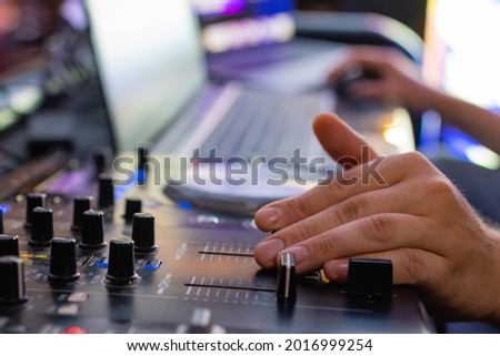 DJ controls a remote at a club party.