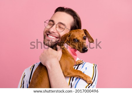 Photo portrait man in t-shirt glasses embracing brown puppy isolated pastel pink color background Royalty-Free Stock Photo #2017000496