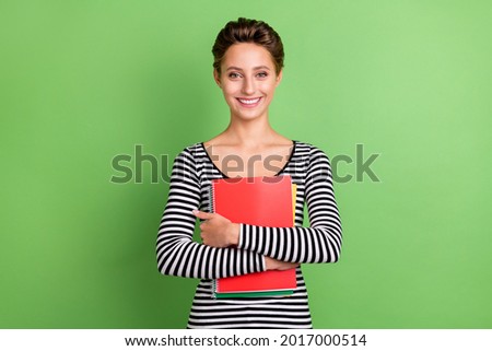 Photo of young charming happy woman hold hands hug notebook good mood isolated on green color background