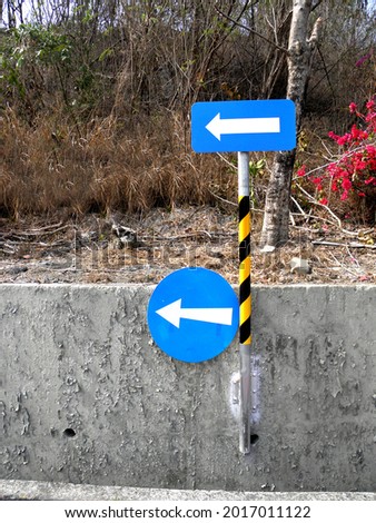 Blue road sign with white arrows pointing in the same direction. Uncertainty, traffic rules, business concepts     