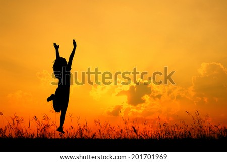 Happy woman jumping and sunset silhouette 
