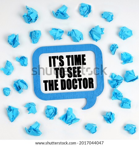 Medicine and health concept. On the table are crumpled blue pieces of paper and a thought plate with the inscription - It s time to see the doctor