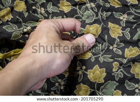 young man hand touching flower cotton fabric pattern background
