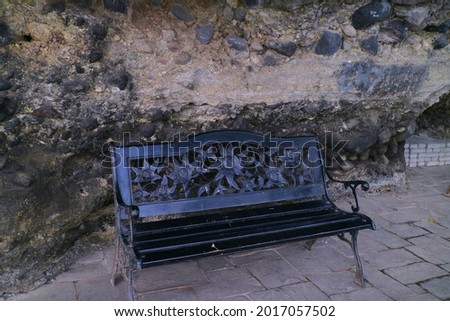 black iron chair under the rock cliff photo