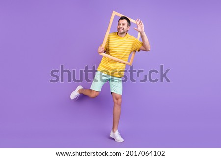 Full length body size photo man waving hand keeping wooden frame isolated pastel violet color background