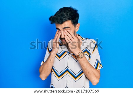 Young hispanic man wearing casual clothes rubbing eyes for fatigue and headache, sleepy and tired expression. vision problem 
