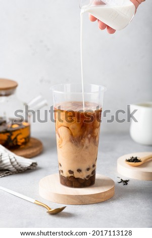 Making milk bubble tea with tapioca in a plastic cup, selective focus Royalty-Free Stock Photo #2017113128
