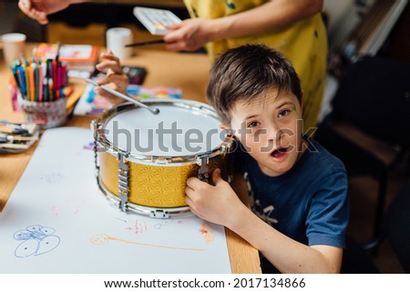 Autistic, Autism or Down Syndrome children boy is playing baraban with his teacher. Studying for disabled kids or autism childs who are down syndrome. Concept disabled child learning in school. Royalty-Free Stock Photo #2017134866