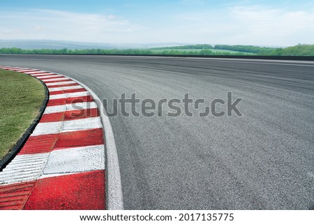 Wide angle close up empty cornering asphalt modern circuit road and blue cloud sky background. Royalty-Free Stock Photo #2017135775