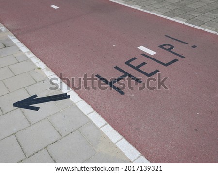 the word help taped with black gaffer tape on a cycle path