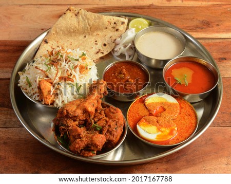 Indian Gavkari Chicken Thali, food platter consists variety of veggies,Chicken meat, lentils,rice, sweet dish, snacks etc., selective focus Royalty-Free Stock Photo #2017167788