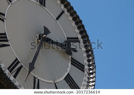 Metal dial and chairs of a street clock in the park