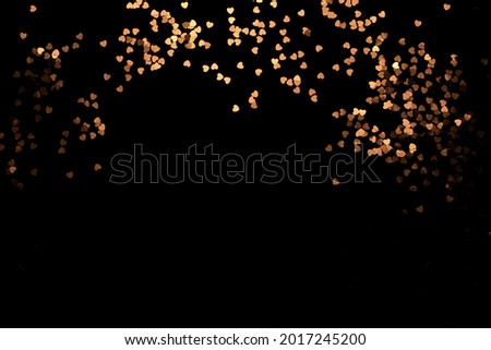 Festive black background with shining heart on black background. Wallpaper vor Christmas, Valentine's Day.  copy space.