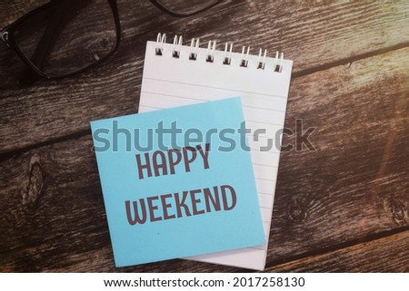 Top view image of sticky note with Happy Weekend wording. 