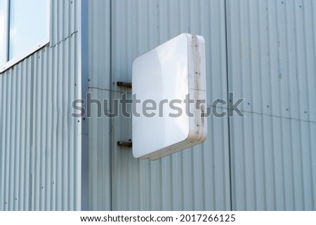 Rectangular light box with company name concrete building wall. Concept of advertising and marketing. mock up
